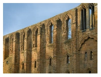 The stone walls of Dunfermline Abbey. The Abbey is a ruin so there are several arches where the windows were.