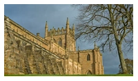 A partial view of the Abbey Church, with focus on one side of the church tower where the word 'Bruce' is carved into the stonework.